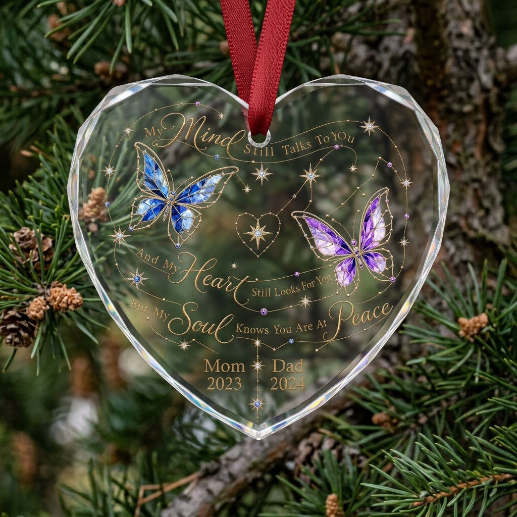 Heart-shaped glass ornament with blue and purple stained-glass butterflies, gold swirls, and memorial text.