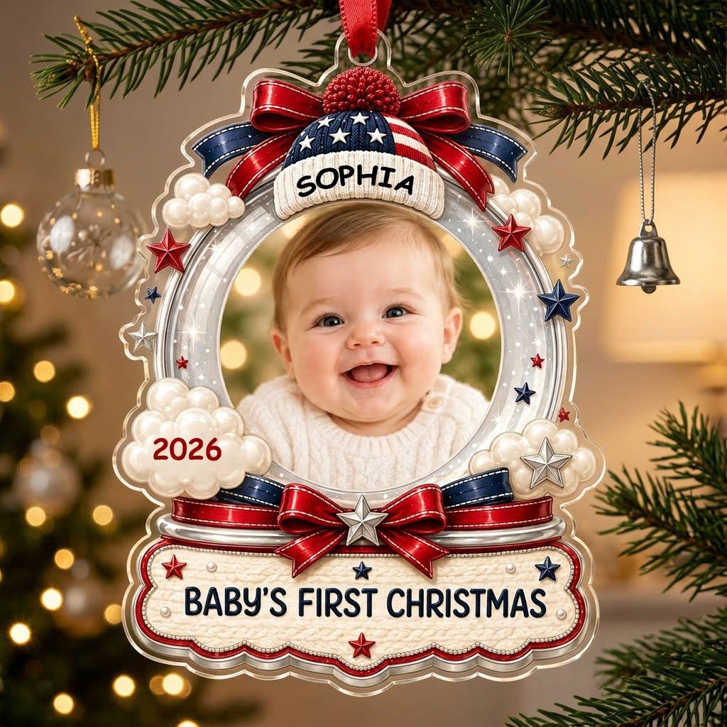 Custom-cut acrylic ornament with baby's photo, patriotic beanie, red bows, stars, and 'Baby's First Christmas' banner.
