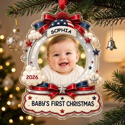 Custom-cut acrylic ornament with baby's photo, patriotic beanie, red bows, stars, and 'Baby's First Christmas' banner.
