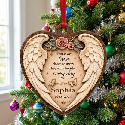 Heart-shaped wood ornament with angel wings, pink roses, butterflies, and a memorial quote with name and dates.