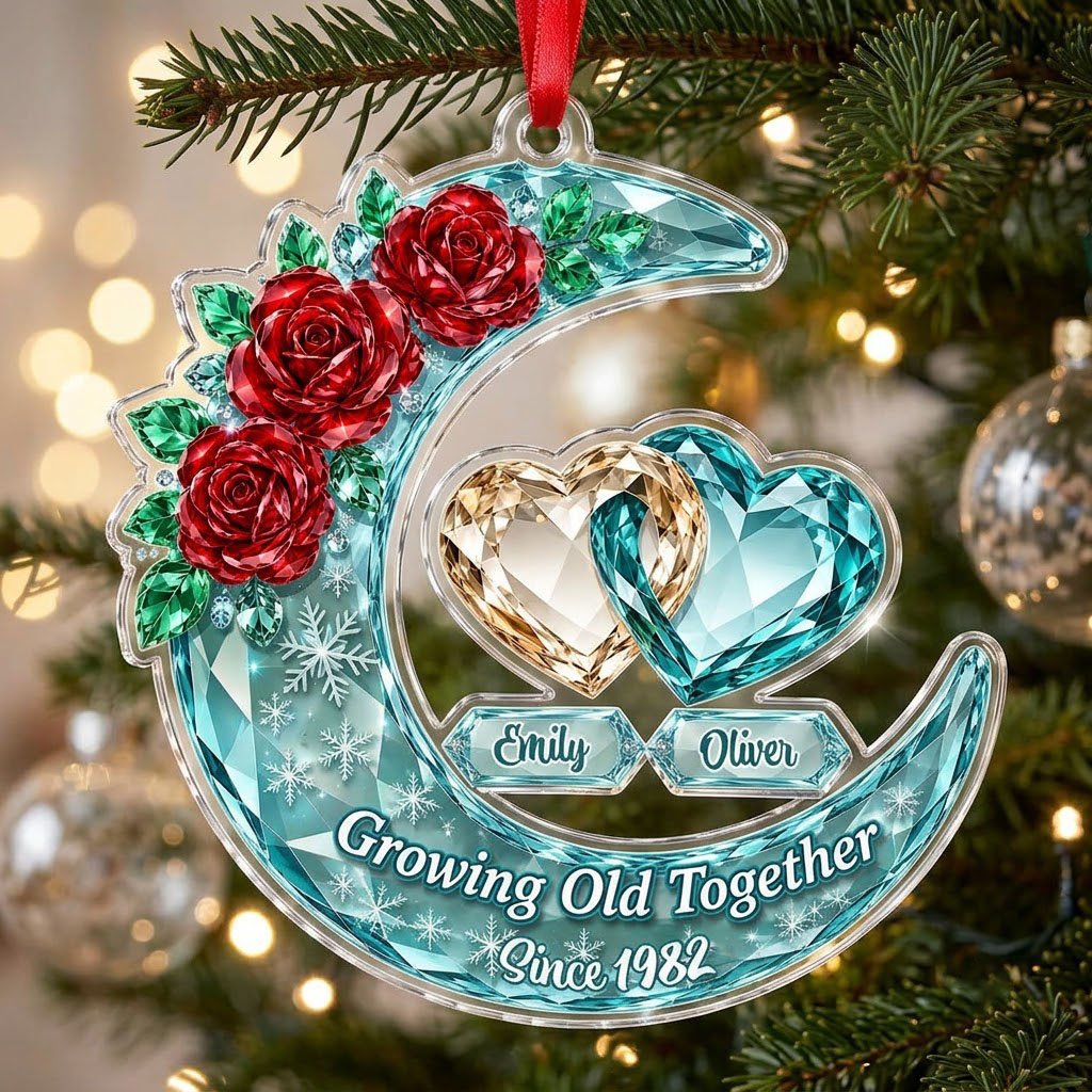 Custom-cut acrylic ornament of a faceted crescent moon with red roses, snowflakes, and two intertwined crystal hearts.