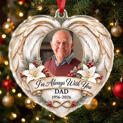 Heart-shaped acrylic ornament with angel wings, oval photo frame, white lilies, pine sprigs, red berries, and 'I'm Alway