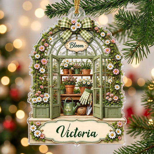 Arched acrylic ornament of a green greenhouse with daisy bow, flowers, tools, and 'Bloom' with a personalized name.