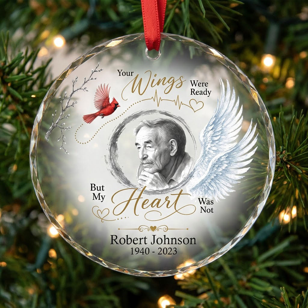 Round glass ornament with a sketch portrait frame, blue angel wing, red cardinal and 'Your Wings Were Ready' memorial te