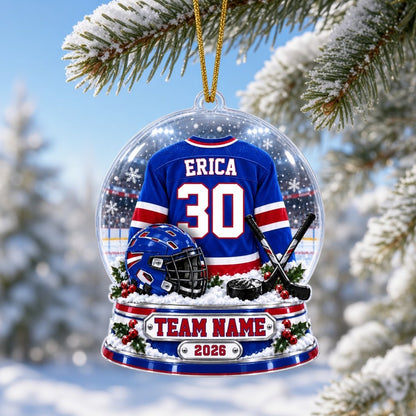 A custom-cut snow globe acrylic ornament with hockey jersey, helmet, crossed sticks, puck, and holly on the base.