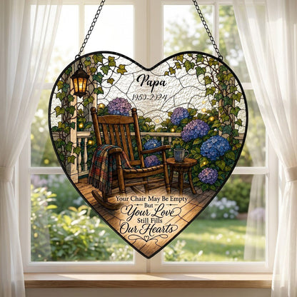 Heart stained glass suncatcher with empty porch rocking chair, lantern, ivy, and purple and blue hydrangea bushes.