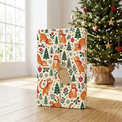 Cream wrapping paper with ginger tabby cats in red scarves, pine trees, hearts, berries, stars, and snowflakes.