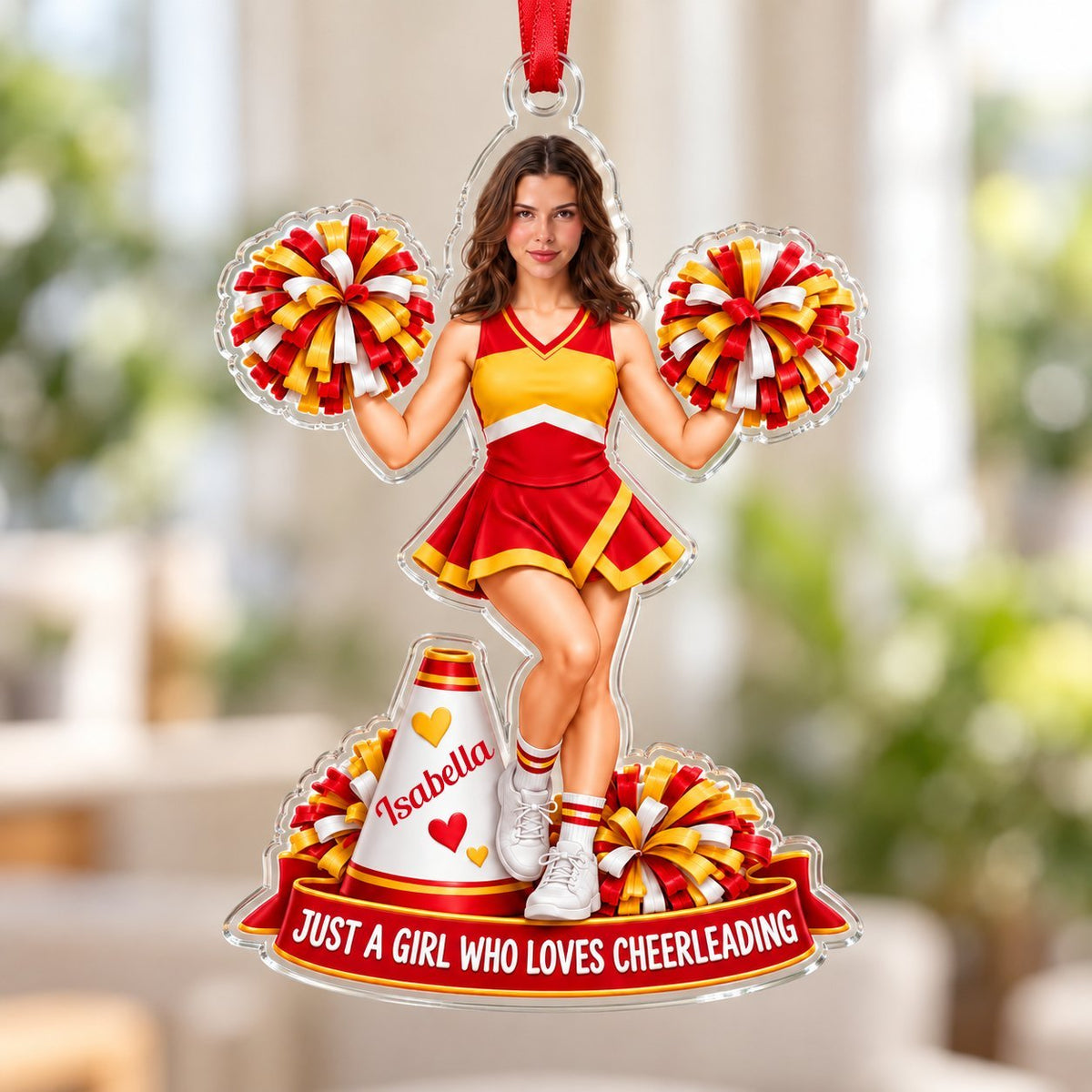 Custom-cut acrylic ornament of a cheerleader in red and yellow with pom-poms, a white megaphone, and a red name banner