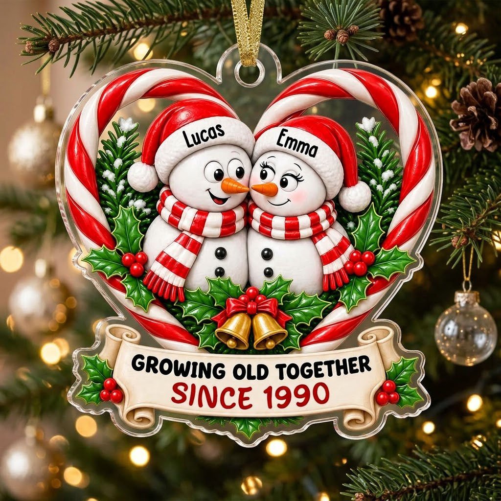 Two snowmen touching noses inside a candy-cane heart with holly, gold bells, and a scroll banner with names and year.