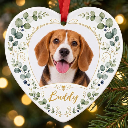 Heart ceramic ornament with a pet photo framed by gold heart scrollwork and eucalyptus with dark blue berries.