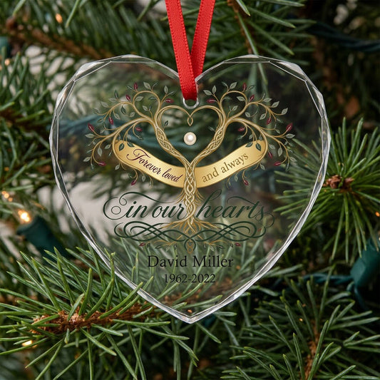 Heart glass ornament with a golden tree of life and the text 'Forever loved and always in our hearts'.
