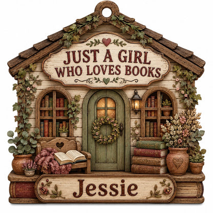 House-shaped wood ornament with 'JUST A GIRL WHO LOVES BOOKS', bookshelves, green door with wreath, and the name Emily.
