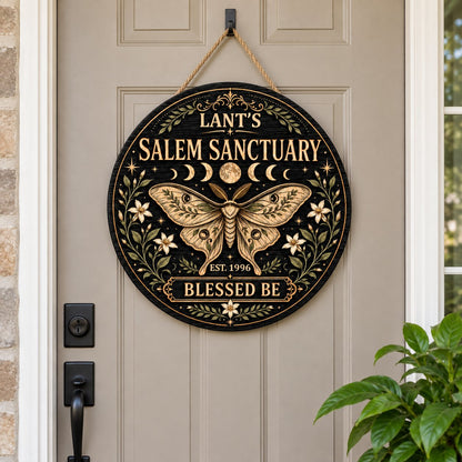 Round wooden sign with a central moth, moon phases, floral vines, stars, and 'Salem Sanctuary' 'Blessed Be' text.