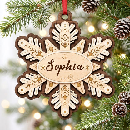 Layered wood snowflake ornament with geometric engravings and a central oval name plate for a custom name.
