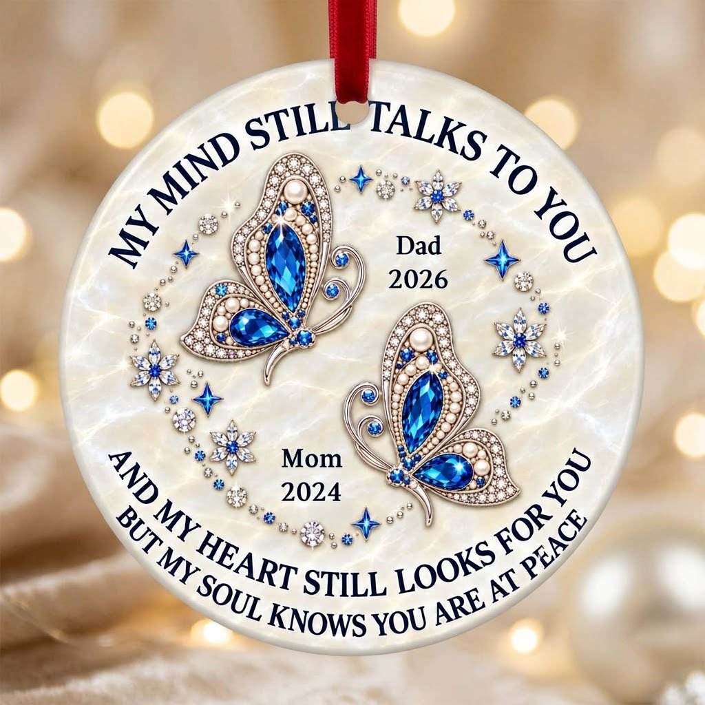 Round ceramic ornament with jeweled blue butterflies, floral rhinestones, and a cream marble background with memorial qu