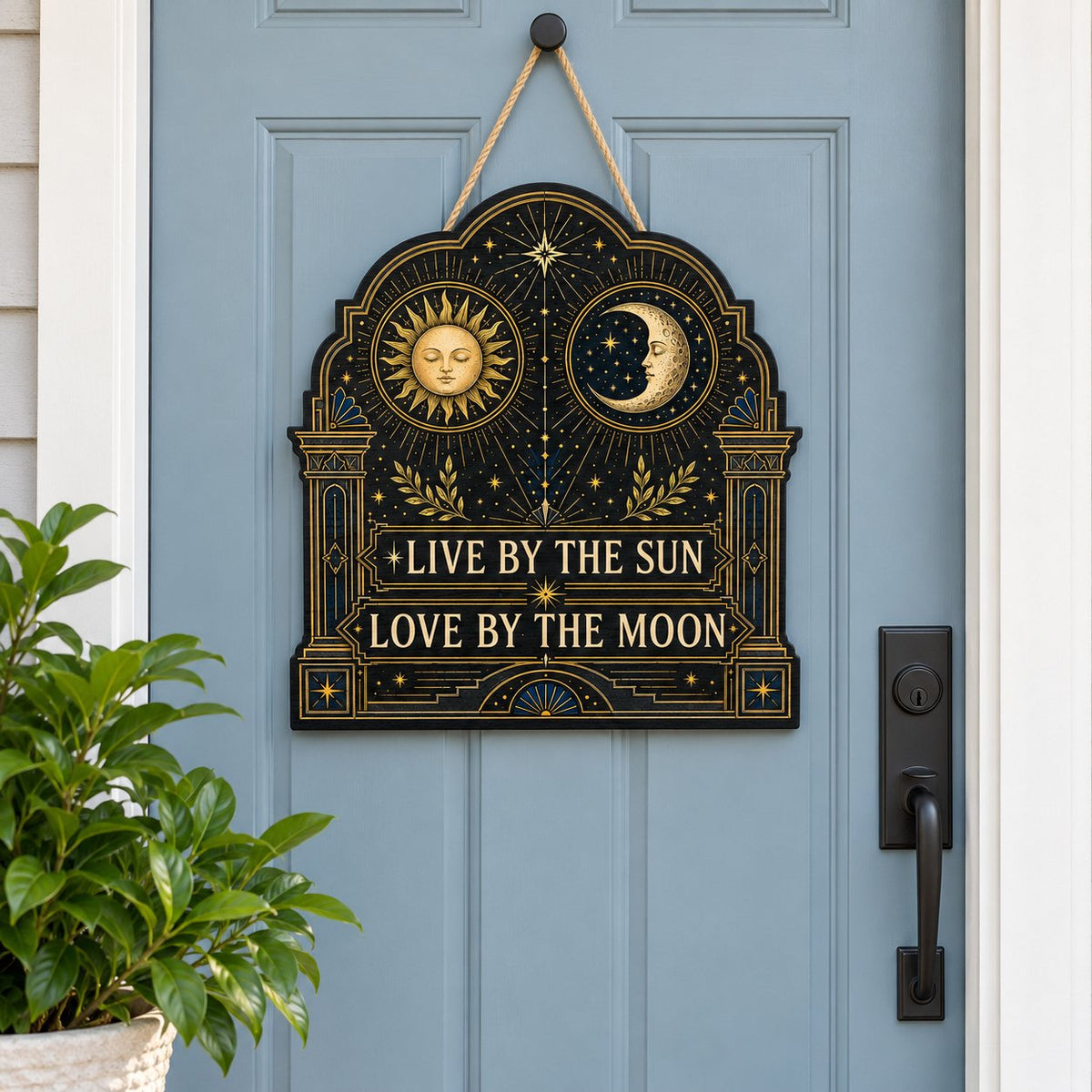 Arched wooden sign with sun and moon faces, constellations, and 'Live By The Sun, Love By The Moon'.
