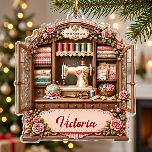 Acrylic ornament shaped like a sewing cabinet with roses, sewing machine, scissors and a pink name banner.