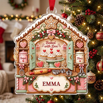 Custom-cut acrylic ornament shaped like a gingerbread house with baking tools, cupcakes, and a name banner.