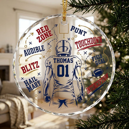 Round faceted glass ornament with football player back view, goalpost, football, and play diagrams in navy, dark red, an