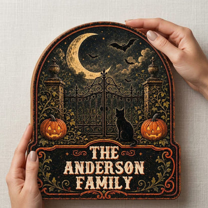 Arched wooden sign with crescent moon, bats, wrought-iron gate, black cat and jack-o'-lanterns with family name.