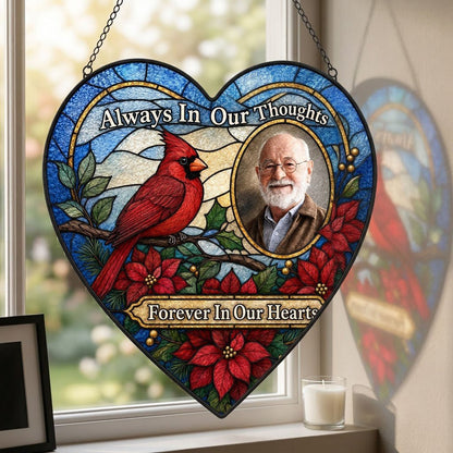 Heart stained glass suncatcher with red cardinal, oval memorial photo frame, and red poinsettias with green leaves.