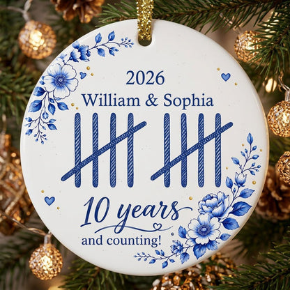 White round ceramic ornament with blue florals, tally marks, and 'years and counting!' plus names and year