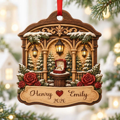 Arched wood ornament with three lanterns, pine trees, red roses, and an open ring box on a central pedestal.