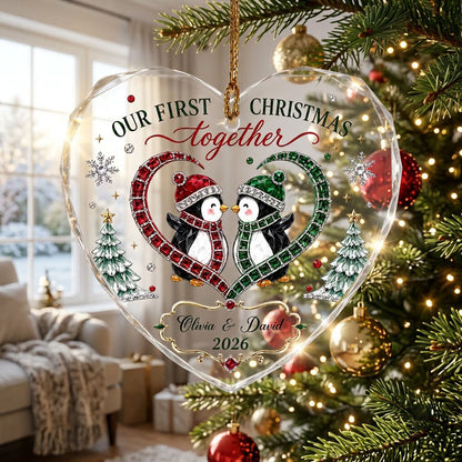 Heart-shaped stained glass suncatcher with two penguins in red and green scarves, jeweled trees, and silver snowflakes