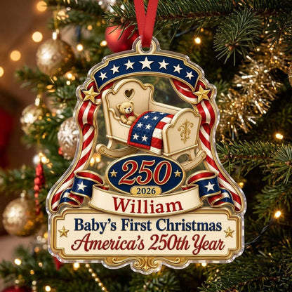 Acrylic ornament with baby crib, teddy bear, patriotic ribbon, and 'Baby's First Christmas', personalized with name and 