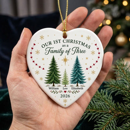 Heart ceramic ornament with three watercolor pine trees, a gold star, red heart garlands, and names with year.
