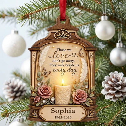 Arched wood-look ornament with lit white candle, two pink roses, butterflies, feathers, and a memorial quote.