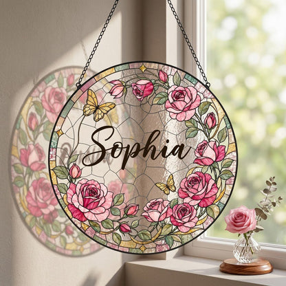 Round stained-glass style suncatcher with pink roses, two yellow butterflies, green leaves, and a decorative patterned b