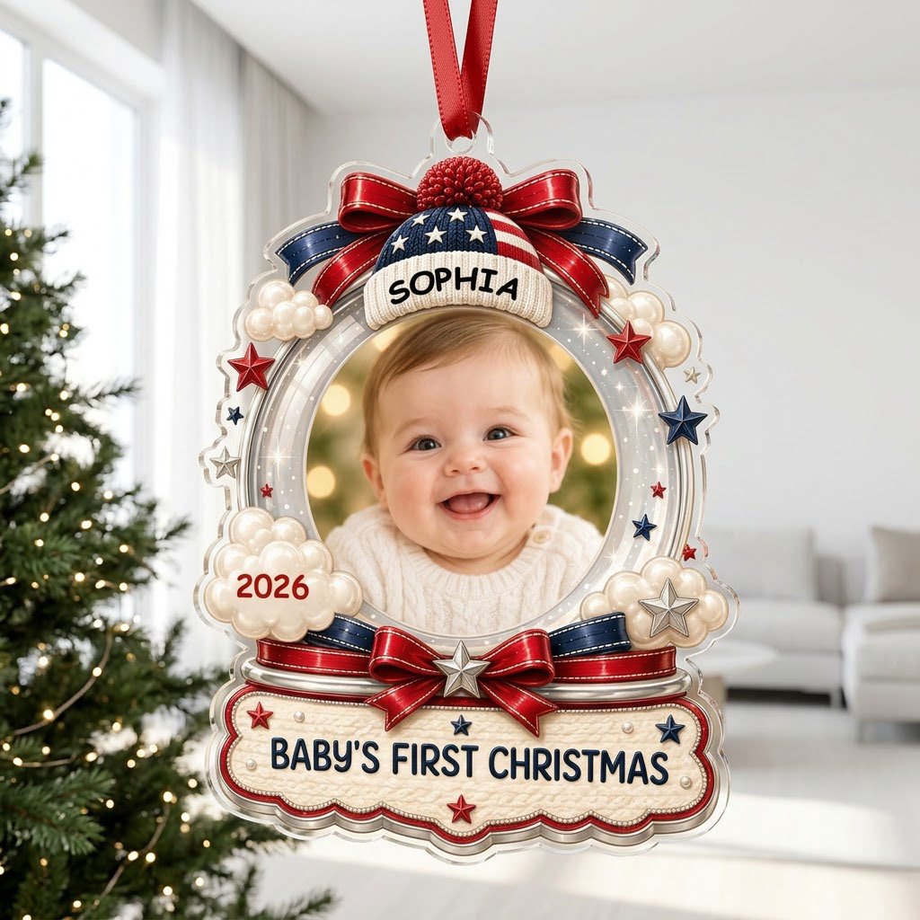 Custom-cut acrylic ornament with baby's photo, patriotic beanie, red bows, stars, and 'Baby's First Christmas' banner.