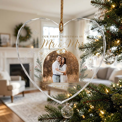 Heart-shaped glass ornament with photo, gold wedding rings, pine branches, snowflakes, and Mr & Mrs text.