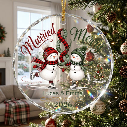 Round glass ornament with two ice-skating snowmen, a scarf ampersand above, and a small Christmas tree with star.
