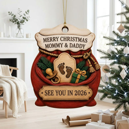 Red Santa sack wood ornament with rope tassels, baby footprints plaque, pacifier, and green gift box.