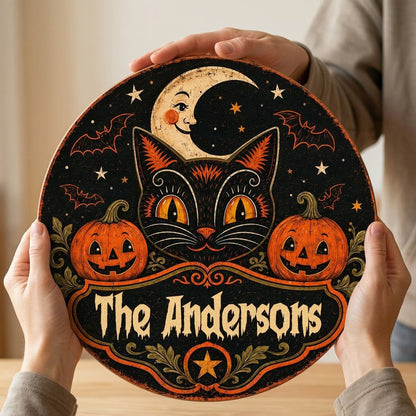 Round wooden sign with vintage black cat face, crescent moon, pumpkins, bats, stars and custom family name.