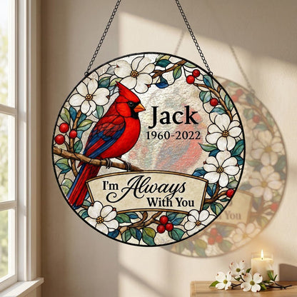 Round stained glass–style suncatcher with a red cardinal on a branch, white flowers, red berries, and a scroll banner.