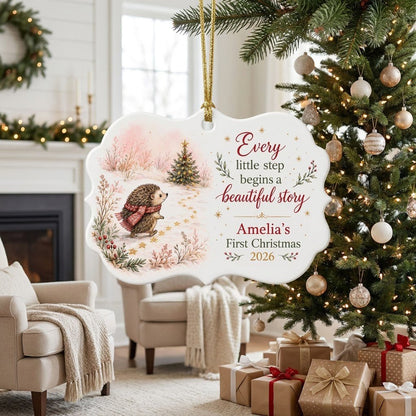Scalloped ceramic ornament with hedgehog in red plaid scarf walking toward a decorated Christmas tree in the snow.