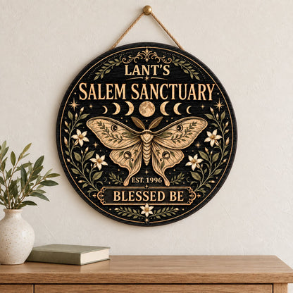 Round wooden sign with a central moth, moon phases, floral vines, stars, and 'Salem Sanctuary' 'Blessed Be' text.