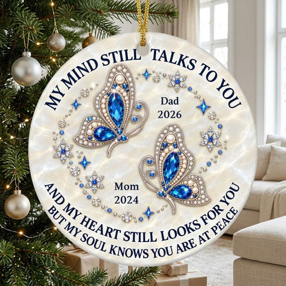 Round ceramic ornament with jeweled blue butterflies, floral rhinestones, and a cream marble background with memorial qu