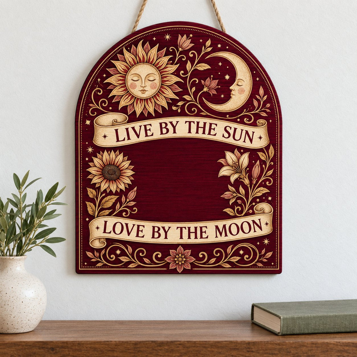 Arch sign with sleeping sun and moon, sunflower and lilies, banners reading Live by the Sun and Love by the Moon.