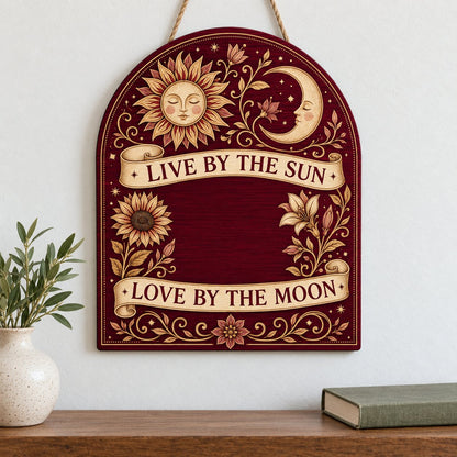 Arch sign with sleeping sun and moon, sunflower and lilies, banners reading Live by the Sun and Love by the Moon.