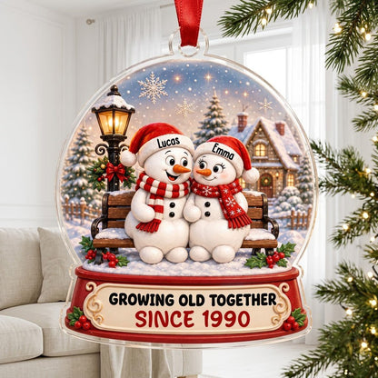Acrylic snowglobe ornament with two snowmen on a bench, Santa hats, and Growing Old Together text.