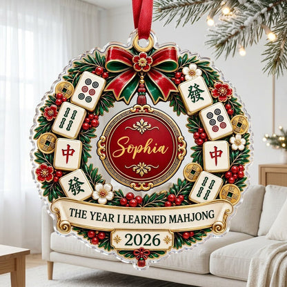 A clear acrylic wreath ornament with Mahjong tiles, red bow, gold coins, and the text THE YEAR I LEARNED MAHJONG.