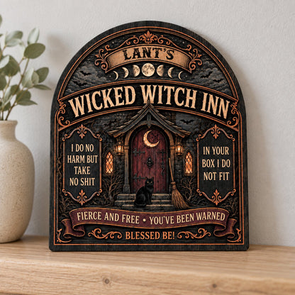 Arch wooden sign with a witch's cottage, bats, moon phases, red crescent door, broom, and a black cat on the steps.