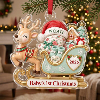 Acrylic ornament of a reindeer pulling a mint-green sleigh with a baby, gifts, and 'Baby's 1st Christmas' text.