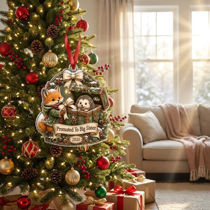 Custom-cut acrylic ornament: fox in jacket, hedgehog in box, pine arch and Promoted To Big Sister banner.