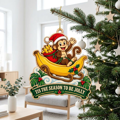 Custom-cut wood ornament with monkey in Santa hat riding a banana sleigh, banner reads TIS THE SEASON TO BE JOLLY.
