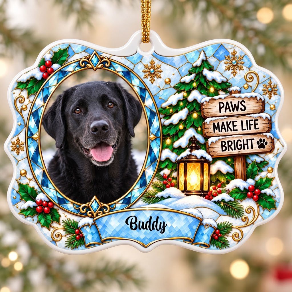 Scalloped ceramic medallion ornament with dog photo, blue stained glass frame, lantern, and Christmas tree in snow.